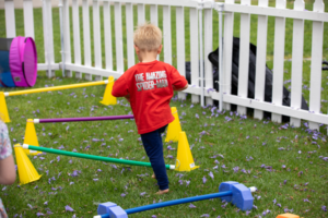 Young Athlete jumping over obstacles at Young Athletes booth at the 2024 Summer Games