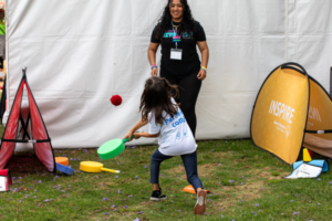 Young Athlete hitting ball with paddle in the Young Athletes booth at the 2024 Summer Games